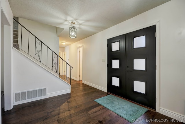 foyer entrance featuring dark hardwood / wood-style flooring and a textured ceiling