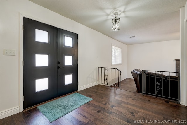 foyer with dark hardwood / wood-style floors and french doors