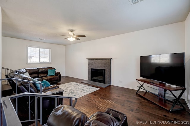 living room featuring dark wood-type flooring and ceiling fan