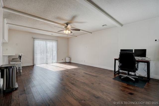 office space featuring dark hardwood / wood-style flooring, ceiling fan, a textured ceiling, and beamed ceiling