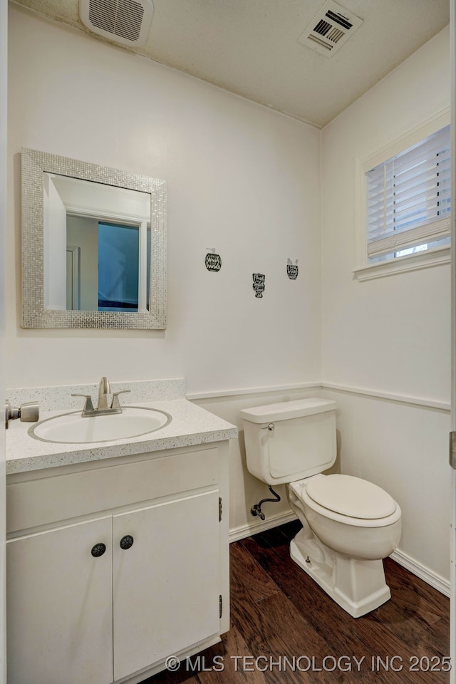 bathroom with hardwood / wood-style flooring, vanity, and toilet