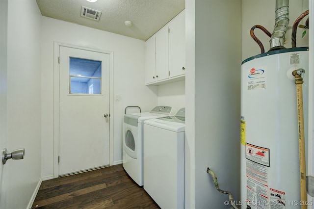 laundry area with water heater, cabinets, dark hardwood / wood-style floors, washing machine and clothes dryer, and a textured ceiling