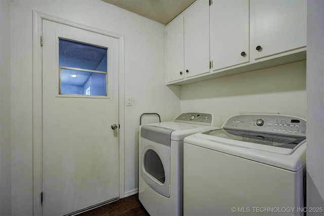 clothes washing area with cabinets and washing machine and dryer