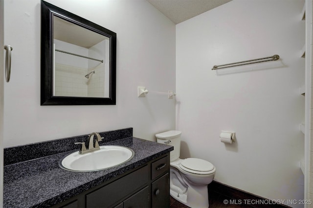 bathroom featuring vanity, toilet, and a textured ceiling