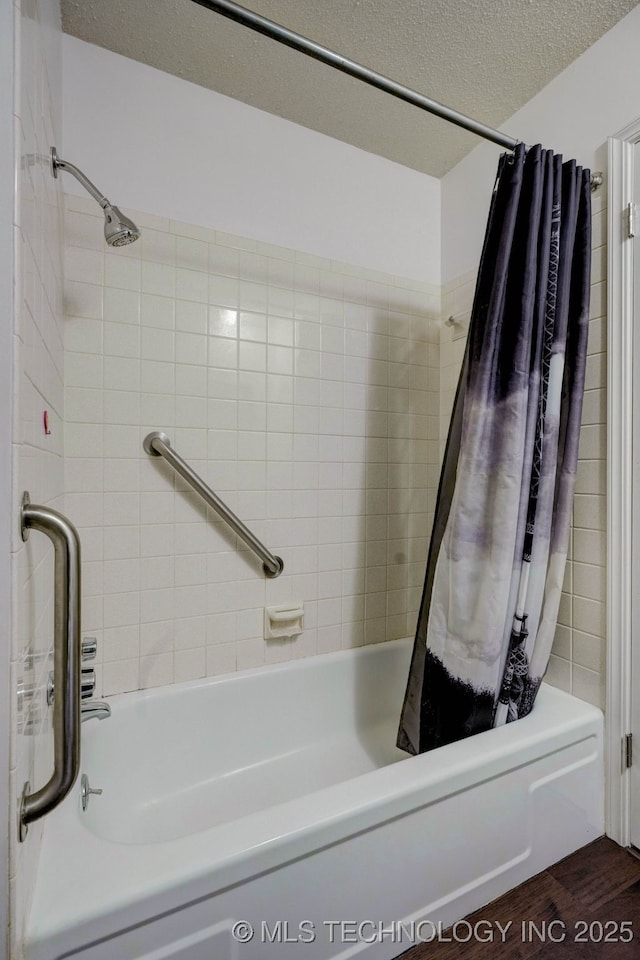 bathroom with shower / bath combo and a textured ceiling