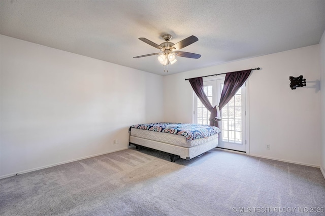 unfurnished bedroom featuring a textured ceiling, carpet floors, and ceiling fan