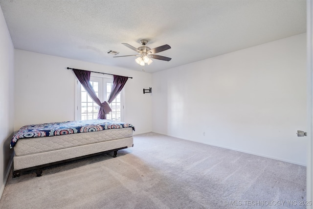 carpeted bedroom featuring a textured ceiling and ceiling fan