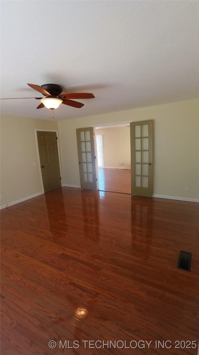 empty room with dark hardwood / wood-style flooring and ceiling fan