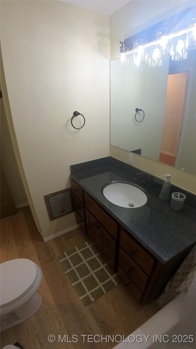 bathroom featuring vanity, hardwood / wood-style flooring, and toilet