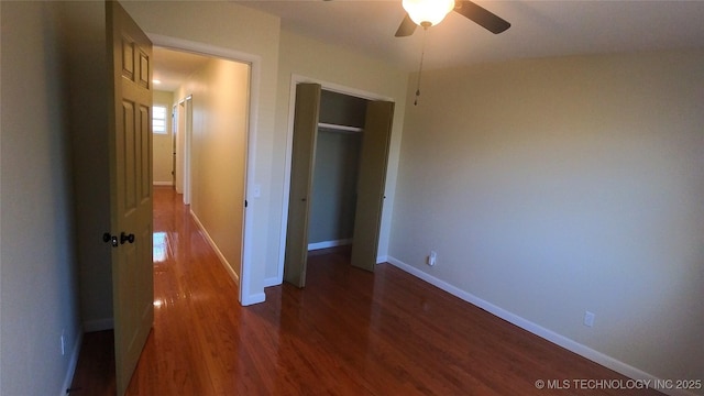 unfurnished bedroom featuring dark wood-type flooring, ceiling fan, and a closet