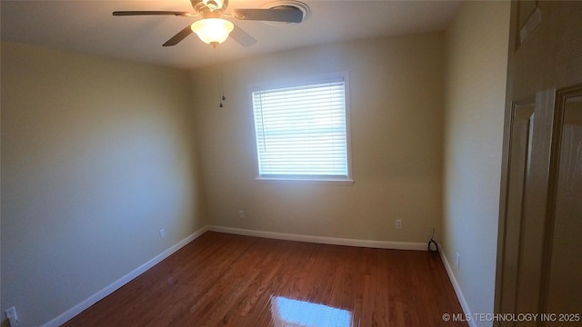 spare room with ceiling fan and dark hardwood / wood-style flooring