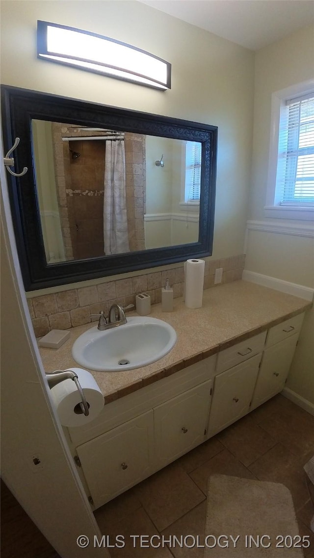 bathroom featuring vanity, tile patterned flooring, and decorative backsplash