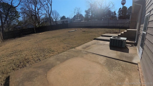 view of yard with central AC and a patio