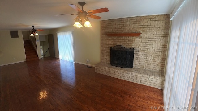 unfurnished living room featuring dark hardwood / wood-style flooring, crown molding, a fireplace, and ceiling fan