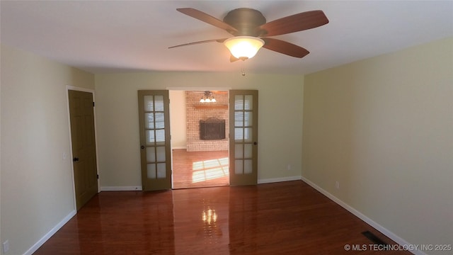 empty room featuring dark hardwood / wood-style floors, ceiling fan, and french doors