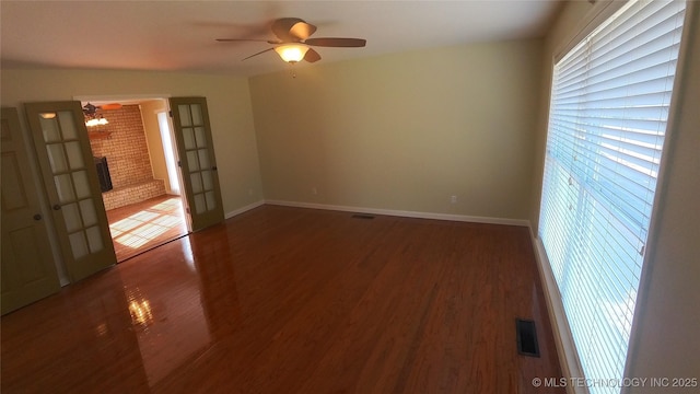 unfurnished room featuring french doors, ceiling fan, and dark hardwood / wood-style flooring