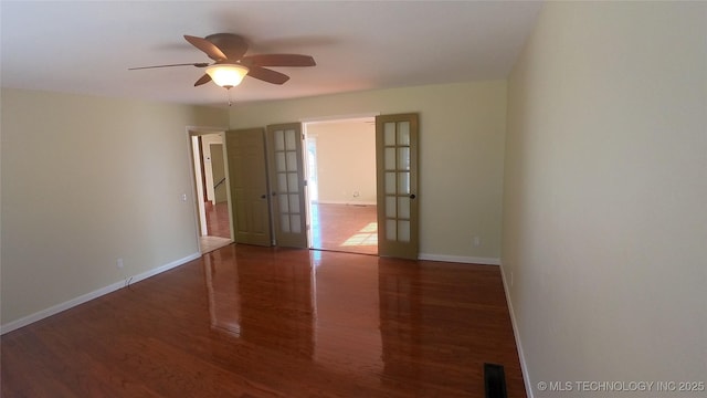 empty room with dark wood-type flooring, french doors, and ceiling fan