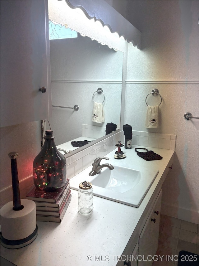 bathroom featuring vanity and a textured wall