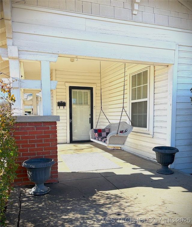 view of exterior entry with a porch