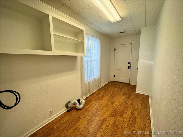 doorway with baseboards and wood finished floors