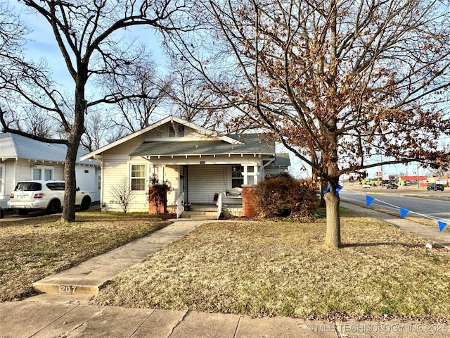 bungalow-style home featuring a porch and a front lawn