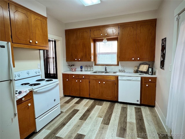 kitchen with sink, white appliances, and light wood-type flooring