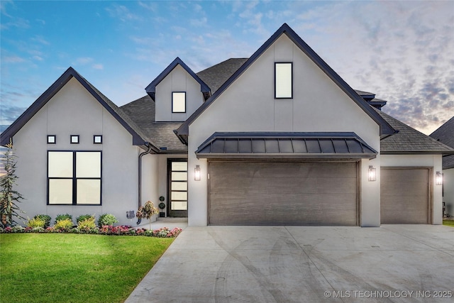 modern inspired farmhouse featuring a garage and a lawn