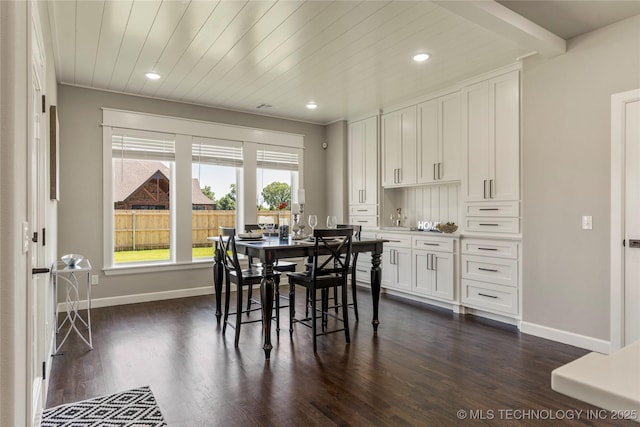 dining room with dark hardwood / wood-style flooring and wooden ceiling