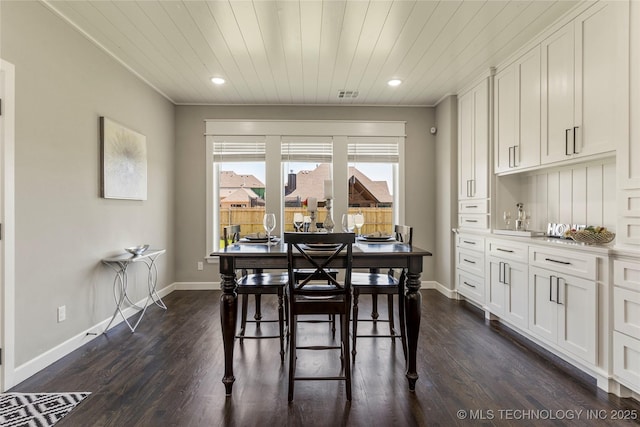 dining room featuring dark wood-type flooring and wooden ceiling