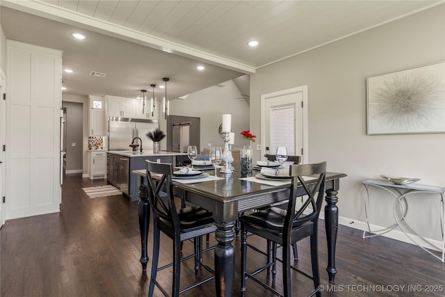 dining room featuring dark wood-type flooring, wood ceiling, and sink