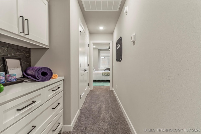 corridor with dark colored carpet