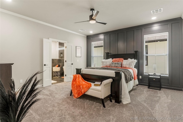 bedroom featuring ensuite bath, ornamental molding, ceiling fan, and carpet