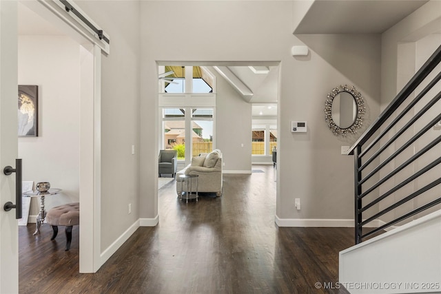 entryway with dark wood-type flooring, plenty of natural light, and a barn door