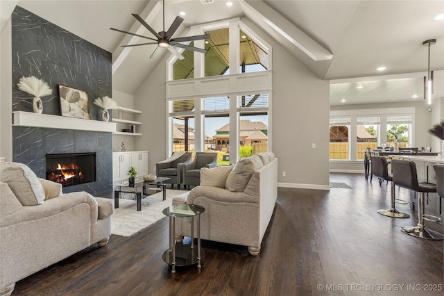 living room with dark hardwood / wood-style floors, high vaulted ceiling, ceiling fan, a high end fireplace, and built in shelves