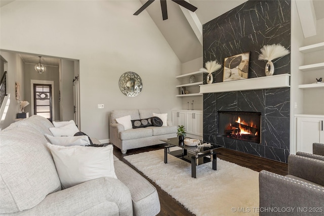 living room with wood-type flooring, a premium fireplace, high vaulted ceiling, and built in features