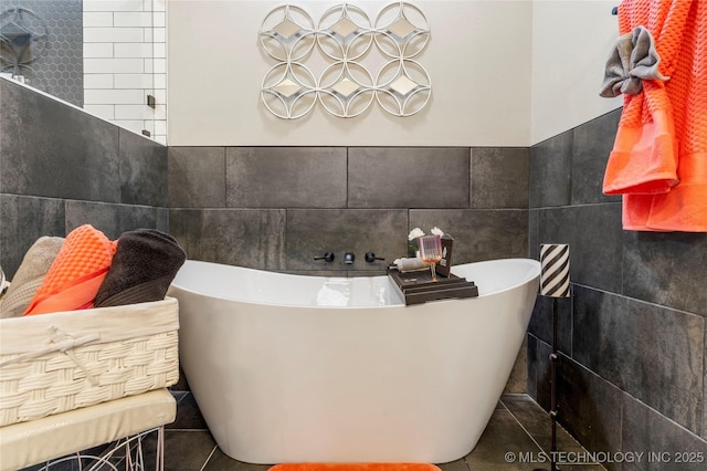 bathroom featuring a washtub and tile walls