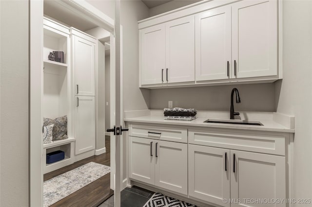 interior space featuring dark tile patterned flooring, sink, and white cabinets