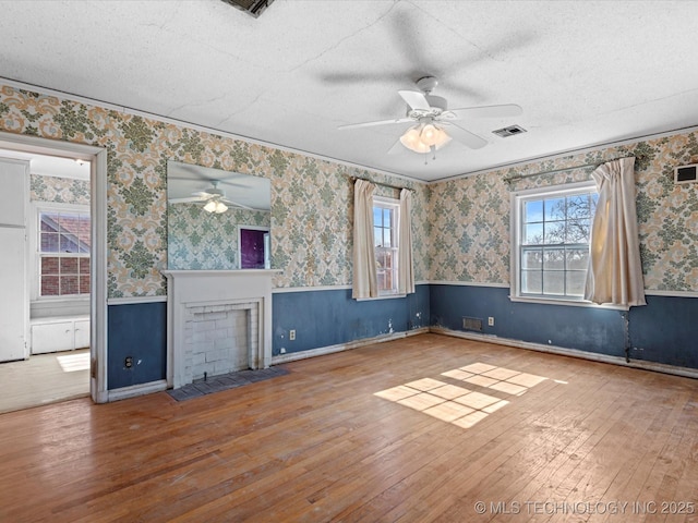 unfurnished living room with ceiling fan, wood-type flooring, and a textured ceiling