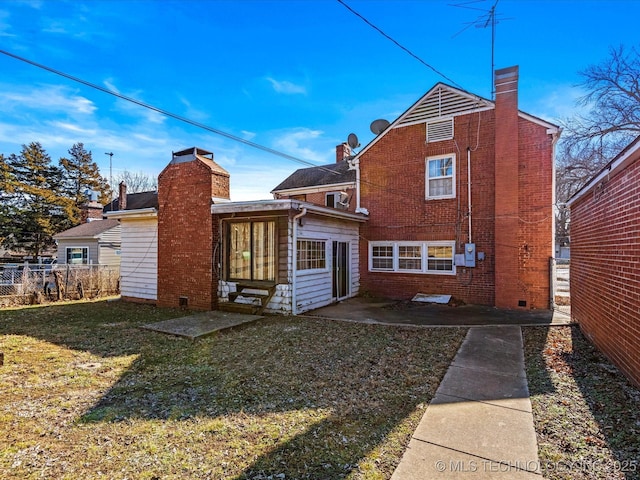 rear view of property featuring a patio and a lawn