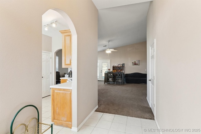 corridor featuring light colored carpet and lofted ceiling