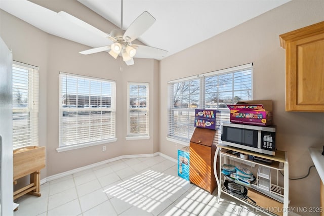 tiled office space with ceiling fan and a healthy amount of sunlight