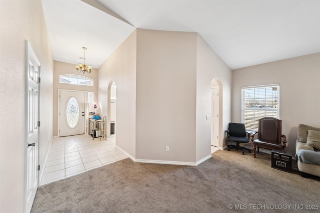 entryway with light carpet, vaulted ceiling, and a chandelier