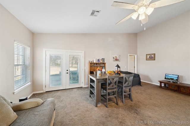 carpeted dining room with french doors and ceiling fan