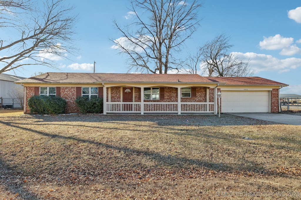 single story home with a garage, a front yard, and covered porch