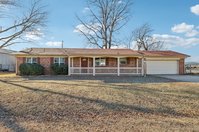 single story home with a garage, a front yard, and covered porch