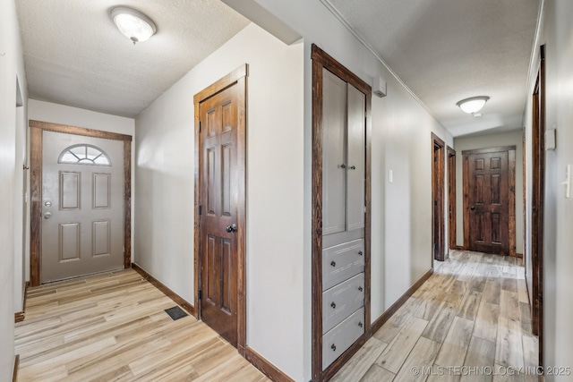 interior space featuring a textured ceiling and light wood-type flooring