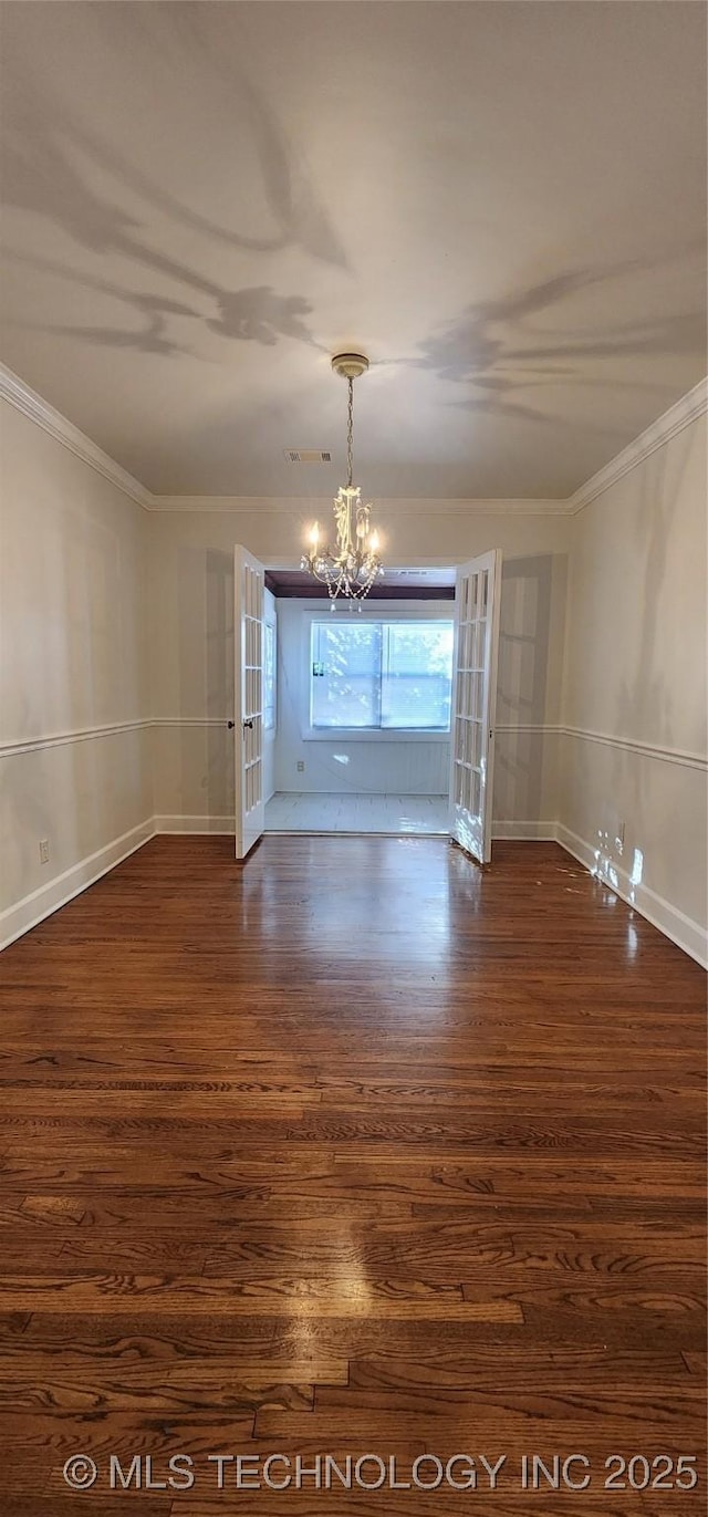 unfurnished room with ornamental molding, dark hardwood / wood-style floors, and a chandelier