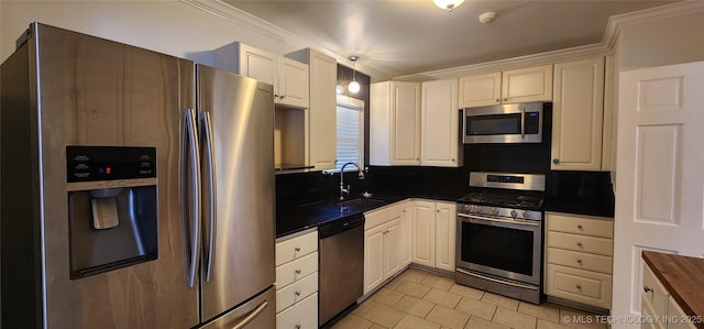 kitchen featuring light tile patterned flooring, white cabinetry, sink, stainless steel appliances, and crown molding