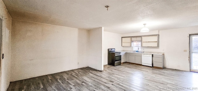 kitchen featuring decorative light fixtures, light hardwood / wood-style floors, white dishwasher, stainless steel gas range, and a textured ceiling