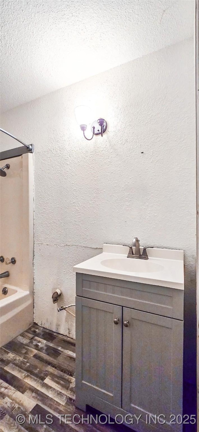 bathroom with wood-type flooring, bathtub / shower combination, and vanity